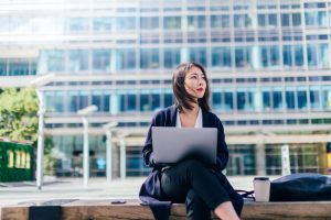 Business-Frau am Notebook als Sinnbild für Embedded Insurance mit Einfluss auf die Bankenbranche