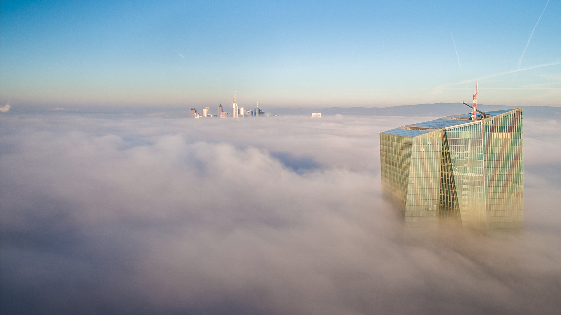 Hochhaustürme, die aus Wolkenhimmel ragen, als Metapher für 2024: Zukunft der Banken unter dem Einfluss globaler Veränderungen